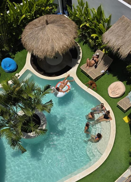 Guests hanging by the pool and swim-up bar at The Lazy Lama Uluwatu